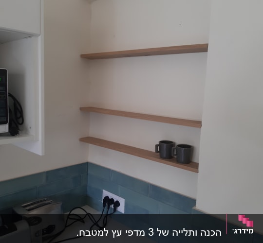 מדפים מעץ מותקנים על קיר במטבח
